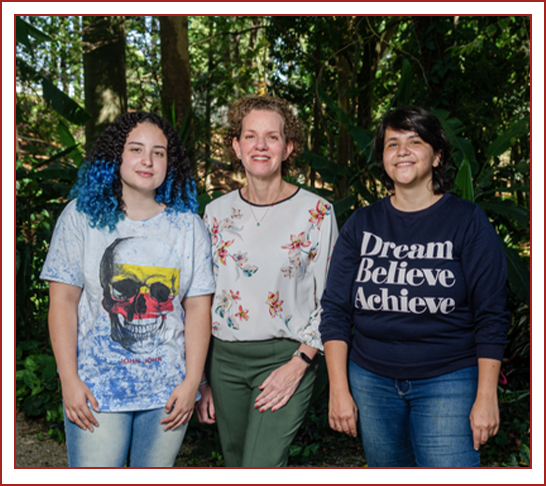 Kalini Camargo, Raquel Barbosa e Tamara Camargo posa, para foto rodeadas por densa vegetação.